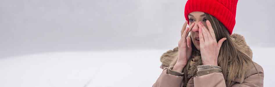 Woman having nasal congestion out in the snow