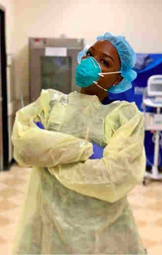 female health care professional wearing a mask with her arms crossed