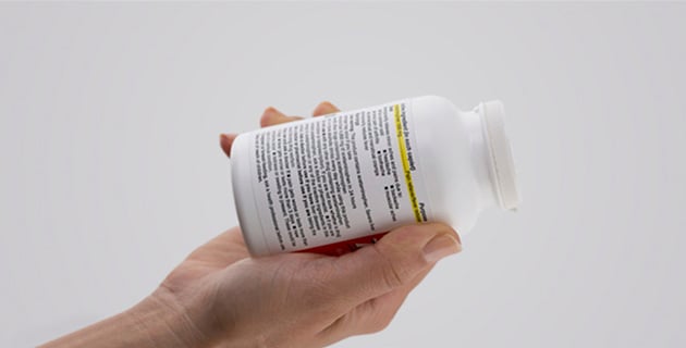 Hand holding a Tylenol bottle with the instructions showing